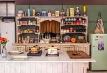 Cozinha vintage com eletrodomésticos, utensílios e objetos decorativos coloridos, criando uma atmosfera nostálgica.