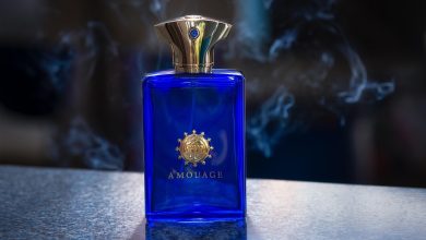 Frasco de perfume envolto por uma atmosfera esfumaçada, em composição escura e abstrata.