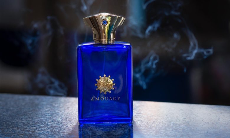 Frasco de perfume envolto por uma atmosfera esfumaçada, em composição escura e abstrata.