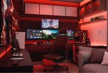 Ambiente doméstico moderno com console PlayStation, computador, fones de ouvido e iluminação vermelha